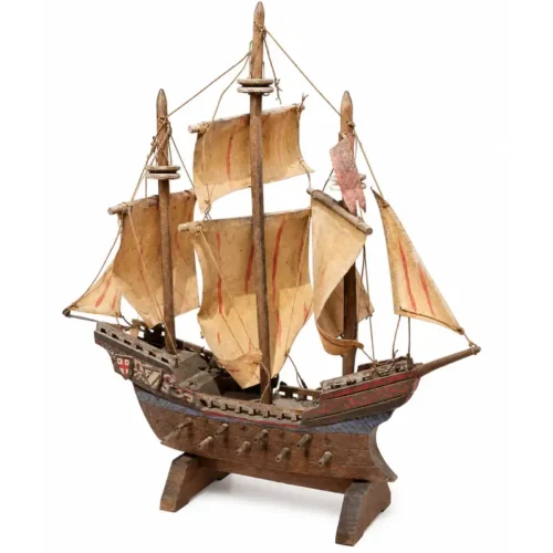 Bateau pirate décoratif en bois avec voiles beiges et mâts, présenté sur fond blanc, disponible à la location pour anniversaire enfant, décor pirate ou événement thématique.