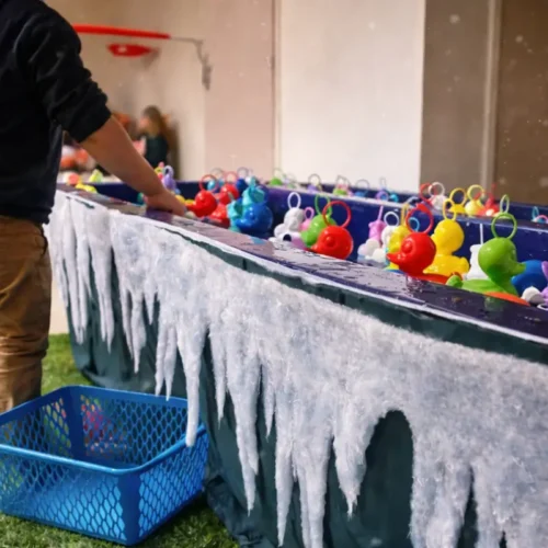 Animation pêche aux canards de Noël avec décor givré, fausse neige et enfant en train de jouer.