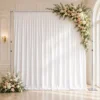 Structure télescopique autoportante avec rideaux blancs, barres latérales visibles et décoration florale dans un décor événementiel élégant.