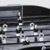 Gros plan sur les joueurs noirs et blancs d’un baby-foot Match René Pierre disponible à la location pour événement.