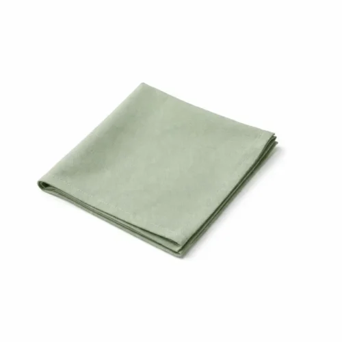 Serviette de table vert sauge pliée en carré sur fond clair.