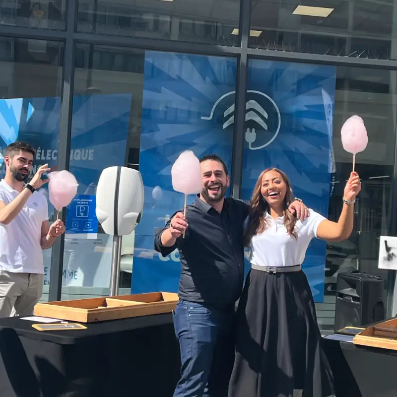 Participants avec des barbes à papa devant un stand de jeux en bois lors des journées portes ouvertes Citroën